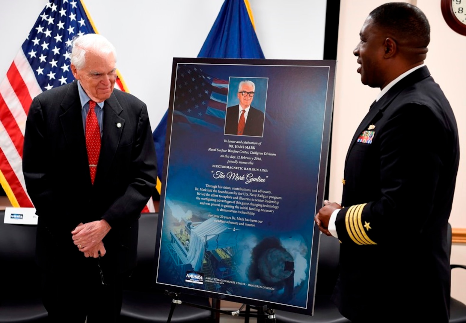 IMAGE: DAHLGREN, Va. (Feb. 22, 2018) – Capt. Godfrey 'Gus' Weekes, right, Naval Surface Warfare Center Dahlgren Division commanding officer, looks over a commemorative poster with Dr. Hans Mark, who along with retired Adm. James Hogg, were honored during an electromagnetic railgun line naming ceremony. As public servants, Hogg and Mark laid the foundation for the U.S. Navy Railgun Program and led the effort to explore and illustrate to senior leadership the warfighting advantages of this game-changing technology and were pivotal in gaining the initial funding necessary to demonstrate its feasibility. (U.S. Navy photo by John F. Williams/Released)
