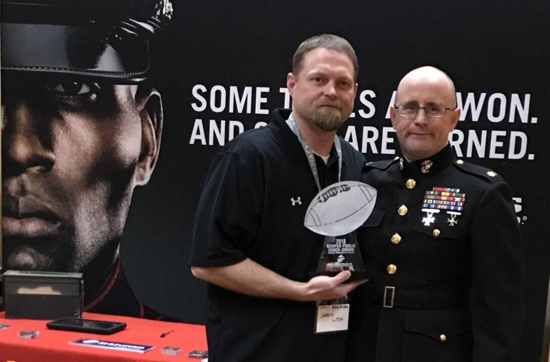 U.S. Marine Corps Maj. Peter E. Ankney, commanding officer of Marine Corps Recruiting Station Salt Lake City, poses with Jared Lish, Bear River High School Football Coach, during the Las Vegas Glazier Clinic Feb. 9, 2018. Ankney presented Lish the Semper Fidelis Coach Award for his embodiment of the Marine Corps motto: Semper Fidelis. Lish not only focused on winning on the field but developing young men and women who can win in life. (U.S. Marine Corps photo by Sgt. Nicole Zurbrugg)