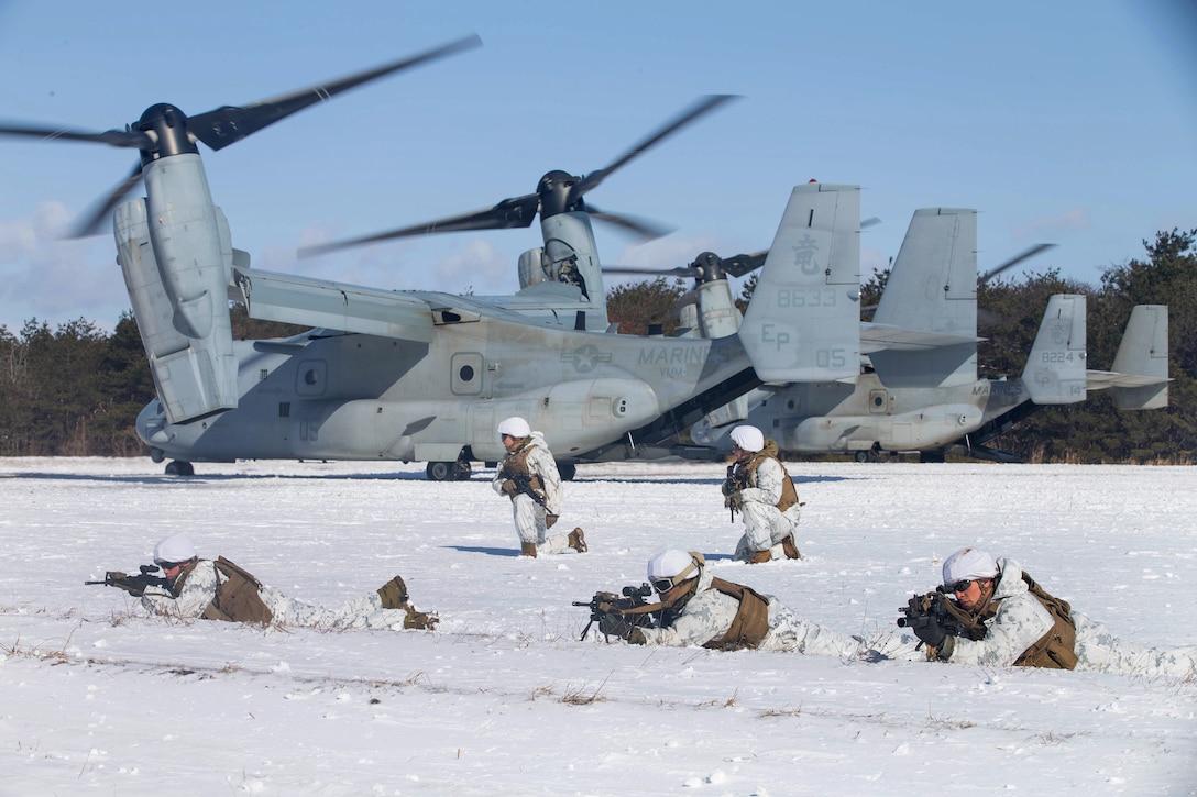 Marines set up a perimeter security around V-22 Osprey aircraft after conducting fast-roping while participating in vertical insertion during Exercise Forest Light.