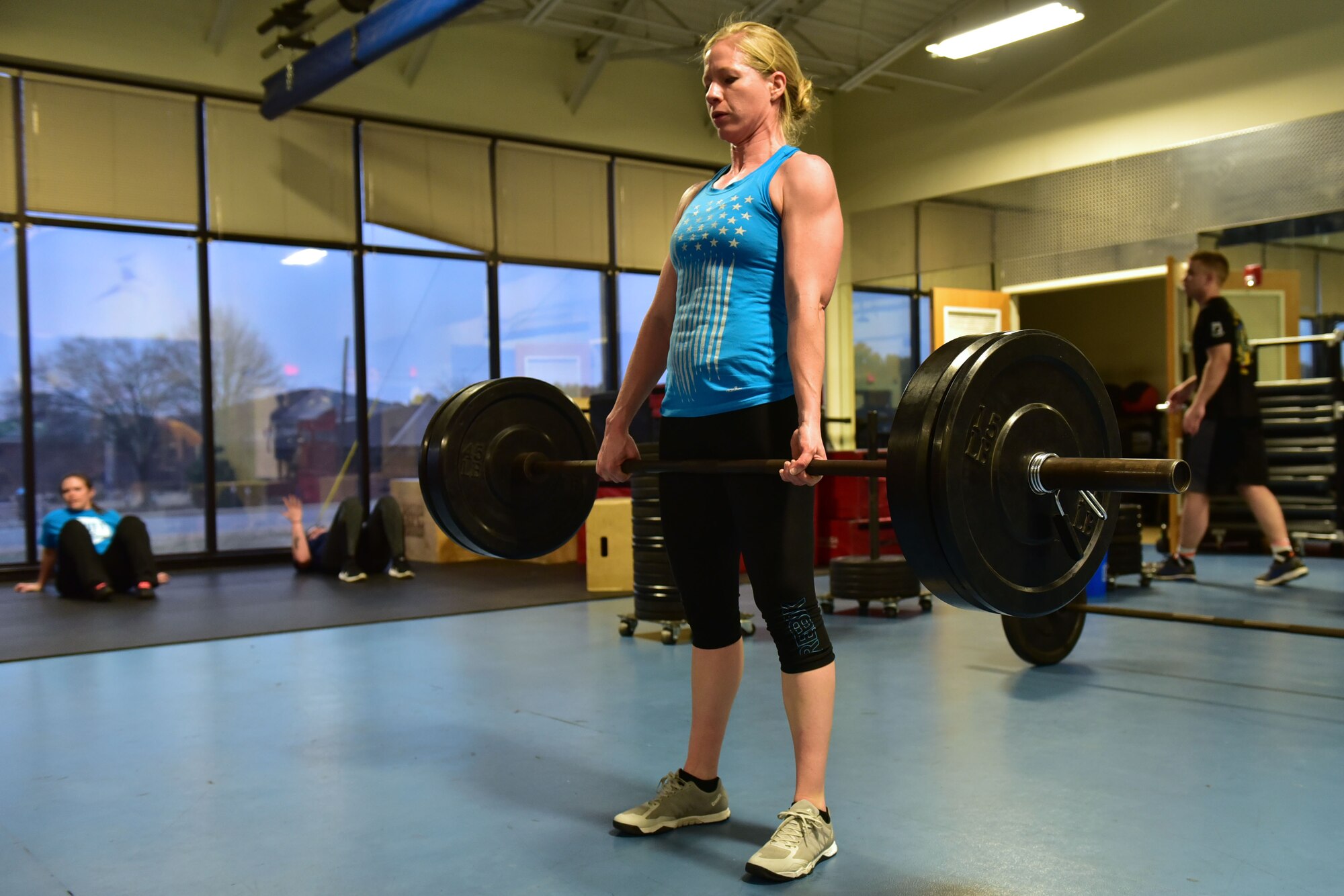 Woman does deadlifts.