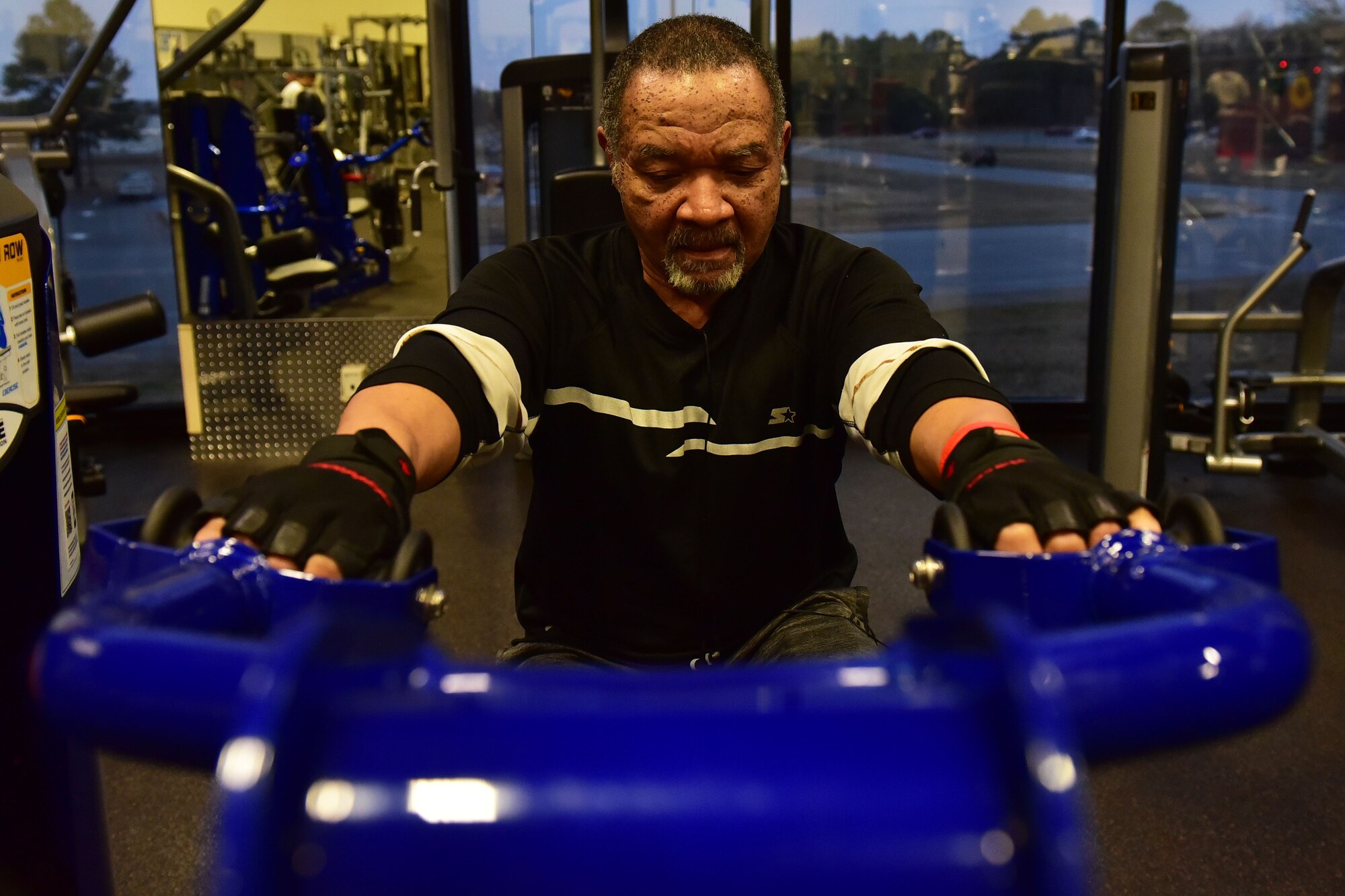 Man pulls weights on weight machine.