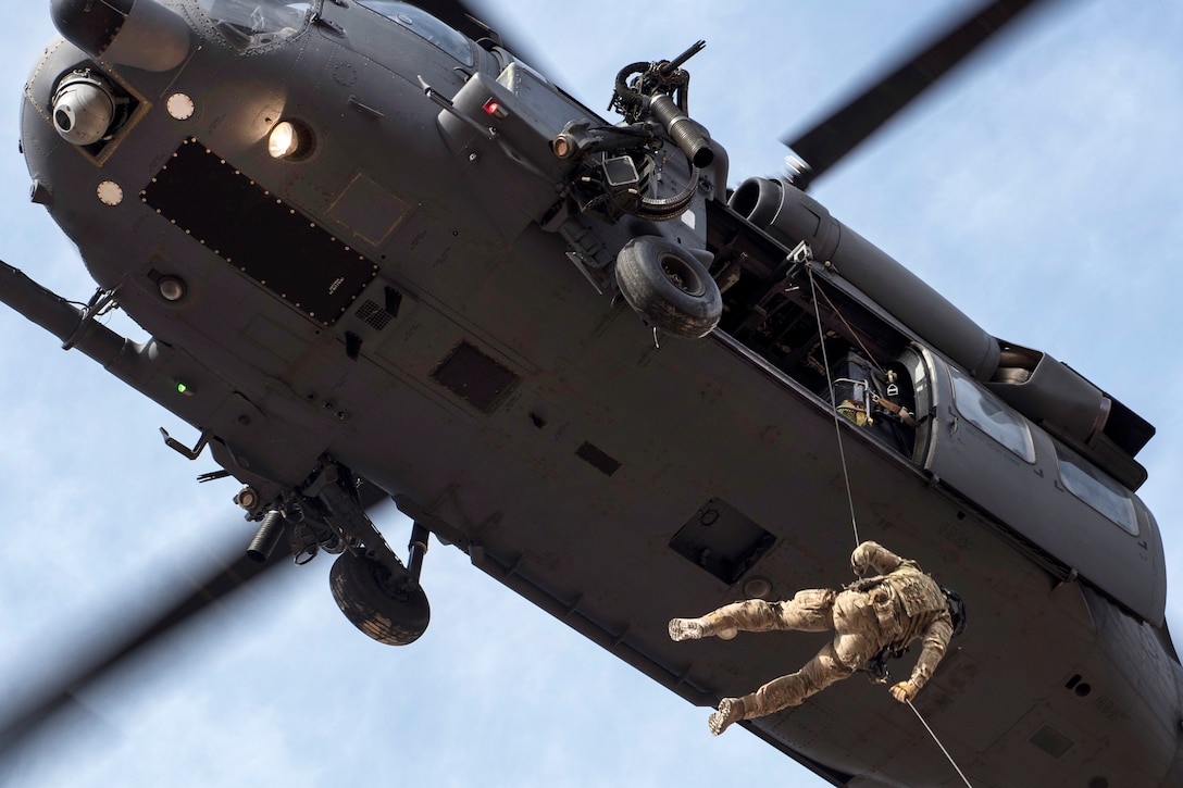 A pararescueman repels out of an HH-60G Pave Hawk helicopter during personnel recovery training.