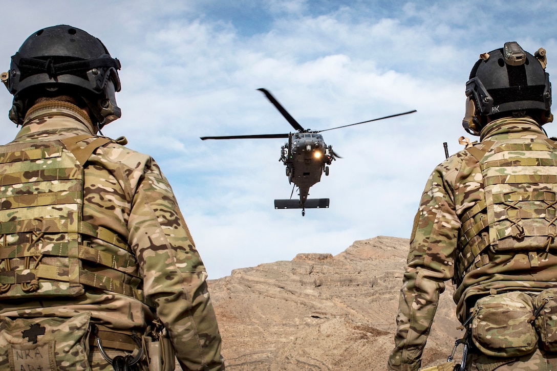 Pararescuemen wait for an approaching HH-60G Pave Hawk helicopter during personnel recovery training.