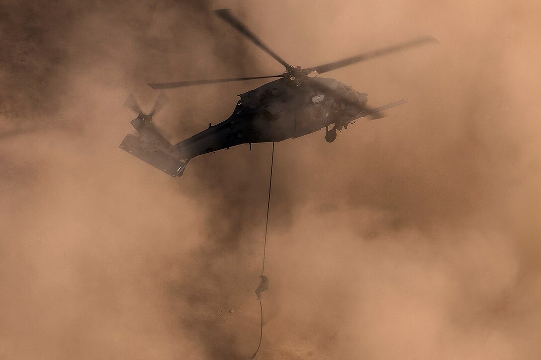 A pararescueman repels out of an HH-60G Pave Hawk helicopter during personnel recovery training.