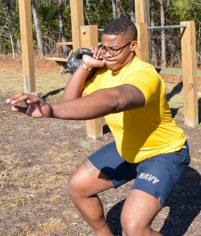 Navy Seaman Nathaniel Mims, a general duty corpsman serving at Naval Health Clinic Charleston, does kettleball exercises during physical fitness training at NHCC. While losing 120 pounds to join the Navy, the Moundville, Alabama native, found a passion for fitness and helping others achieve their fitness goals