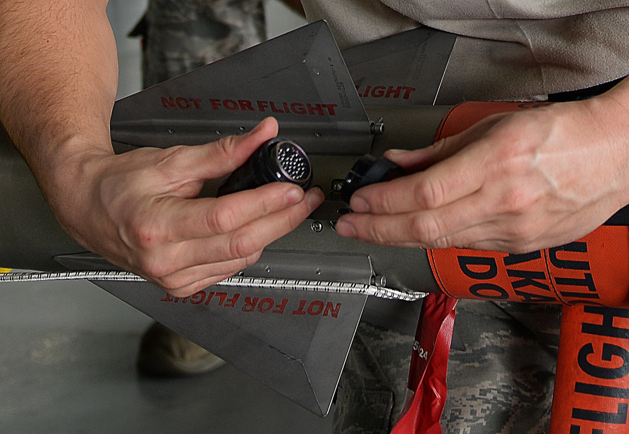 U.S. Air Force Airman 1st Class Robert Neu, 79th Aircraft Maintenance Squadron load crew member, checks an umbilical receptacle on an Air Integrated Missile 9 to make sure there is not damage at Shaw Air Force Base, S.C., Feb. 23, 2018.