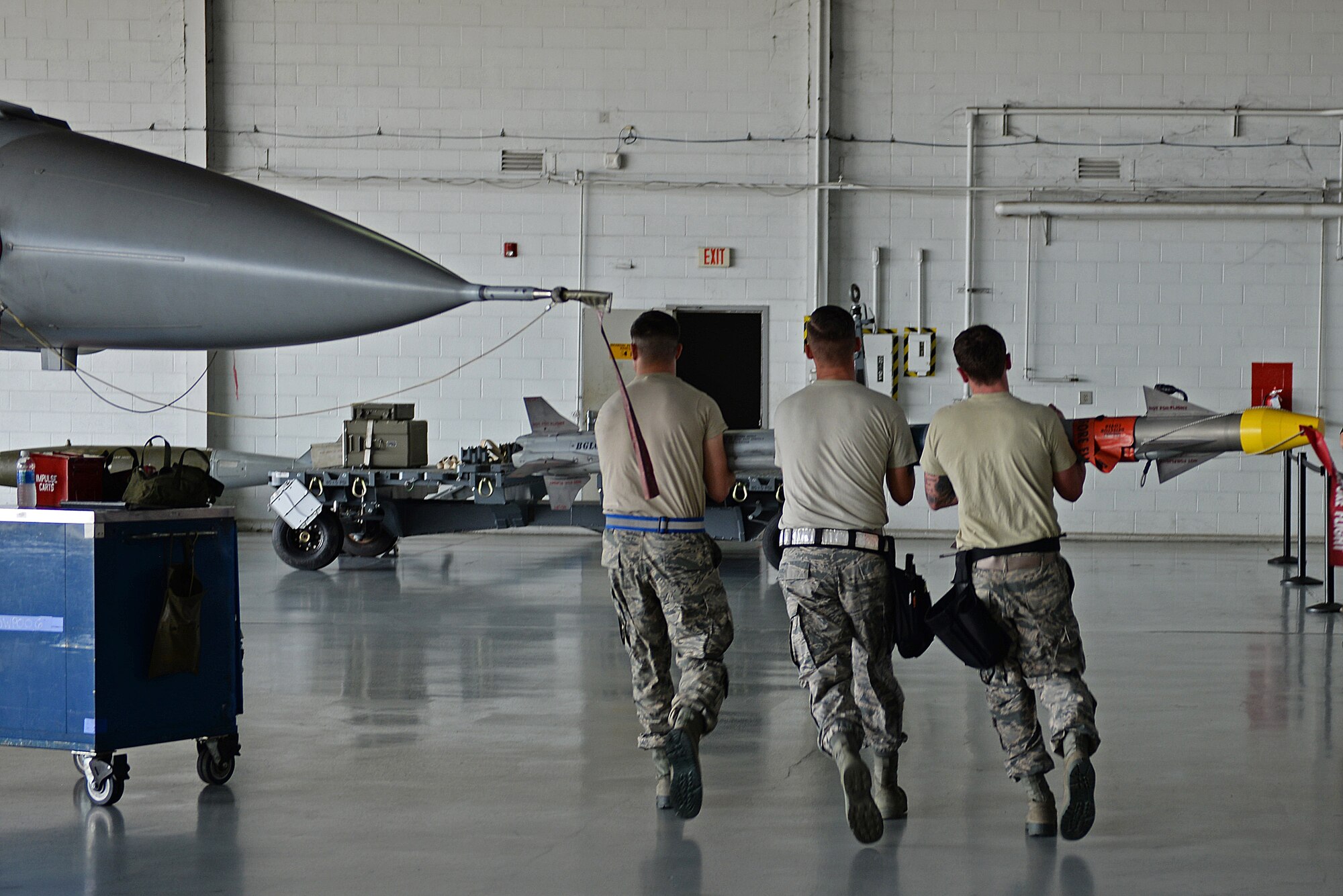 Airmen from the 55th Aircraft Maintenance Squadron, Shooters, work together to lift an Air Integrated Missile 9 and load it into an F-16CM Fighting Falcon at Shaw Air Force Base, S.C., Feb. 23, 2018.