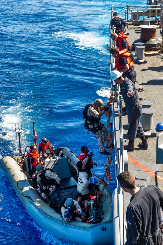 Sailors board a rigid hull inflatable boat aboard Ticonderoga-class guided-missile cruiser USS Lake Champlain.