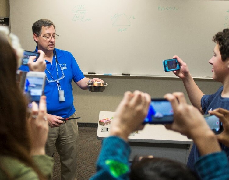 Local high school students use their phones to record a fire-safety demonstration that is part of the Air Force Institute of Technology Demo Days Feb. 21, 2018, on Wright-Patterson Air Force Base, Ohio. (U.S. Air Force photo by R.J. Oriez) (CAC badge was obscured for security reasons)