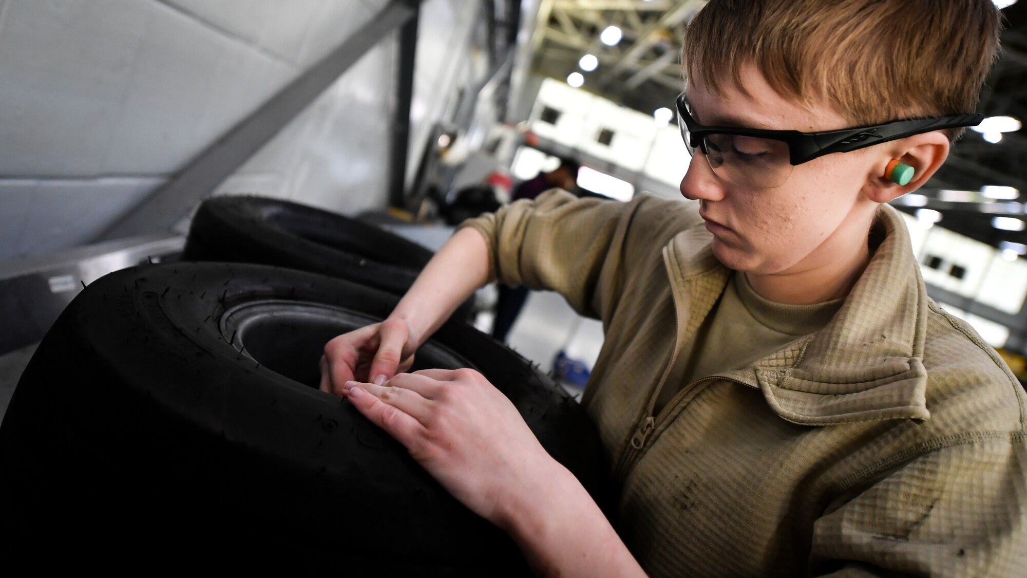 Airman Abigail Weber, 2nd Maintenance Squadron aerospace ground equipment technician, releases air from a bomb loader vehicle tire at Barksdale Air Force Base, La., Feb. 27, 2018. Tires that are found to have defects are replaced.