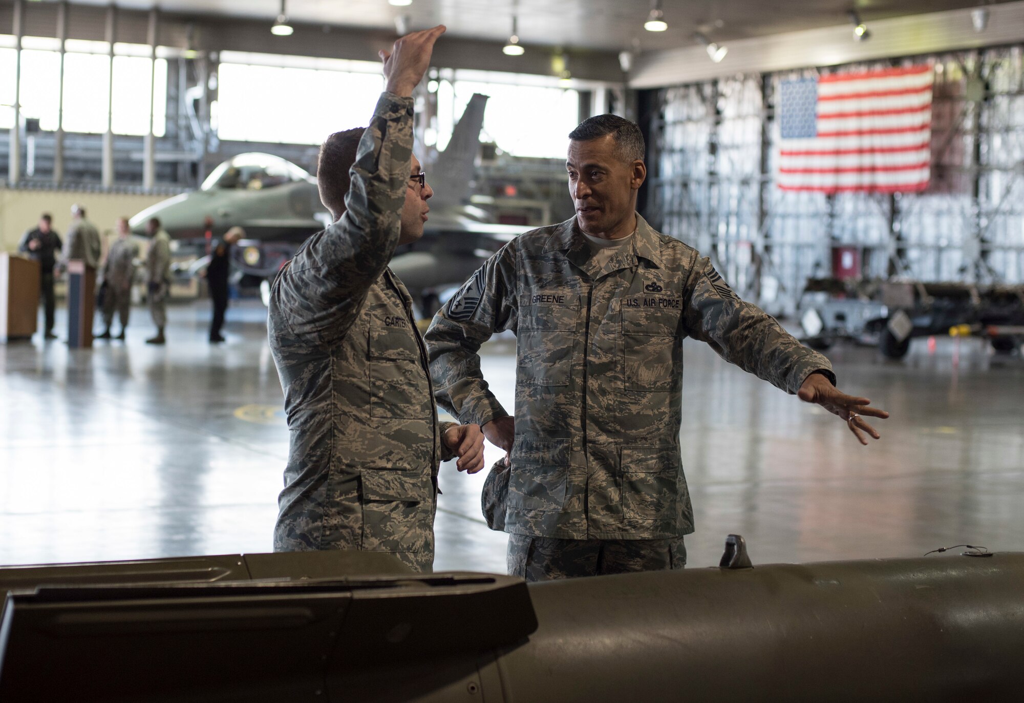 U.S. Air Force Senior Airman Robert Carter, left, a 35th Maintenance Group weapons load crew member, showcases displayed munitions to Chief Master Sgt. Terrence A. Greene, right, the United States Forces Japan and Fifth Air Force command chief, during his tour at Misawa Air Base, Japan, Feb. 23, 2018. Greene stressed the importance of Airmen knowing their mission and how their individual actions contribute to stability across the region. (U.S. Air Force photo by Airman 1st Class Collette Brooks)