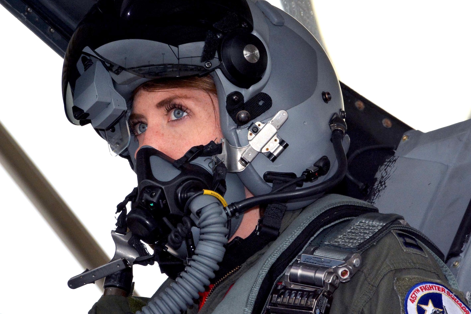 A pilot looks forward while sitting in a cockpit.