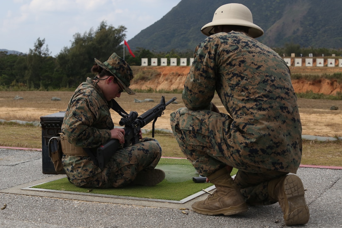 CAMP SCHWAB, OKINAWA, Japan – A range coach observes as a Marine preforms remedial action to remove a jammed round on the rifle range Feb. 14 aboard Camp Schwab, Okinawa, Japan.