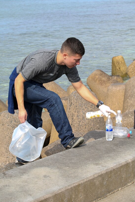 Lance Cpl. Victor Diaz picks up plastic bottles during a beach cleanup Feb. 24 at Sunabe Seawall, Okinawa, Japan. Twenty-one Marines with the Single Marine Program from Camp Courtney visited the seawall to help clean up debris along the beach. Diaz is a network administrator with Headquarters Battalion, 3rd Marine Division. (U.S. Marine Corps photo by Pfc. Nicole Rogge)