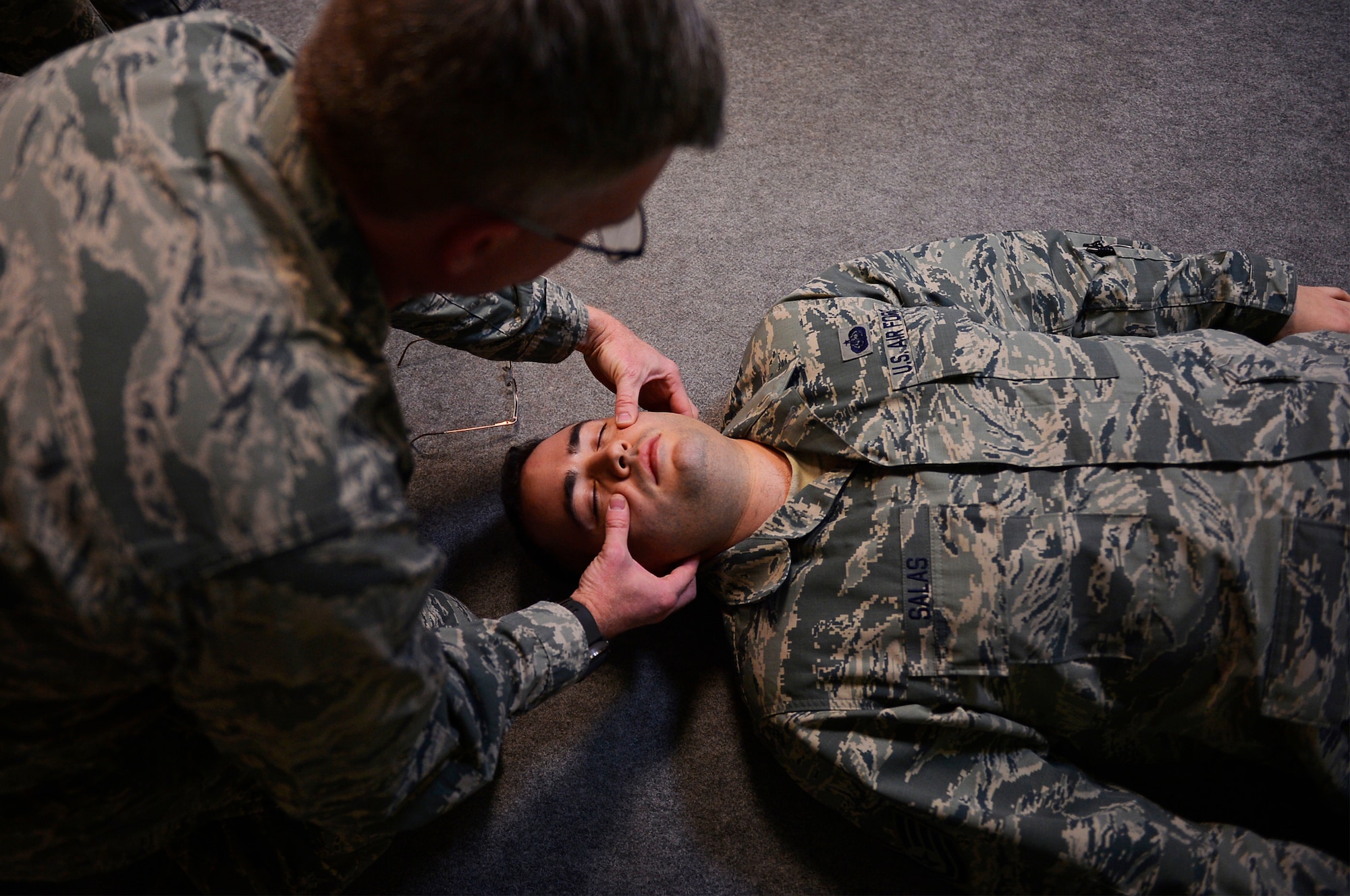 U.S. Air Force Capt. Jeremy Bull, 313th Expeditionary Operations Support Squadron flight nurse, demonstrates self-aid buddy care techniques on U.S. Air Force Tech. Sgt. Peter Salas, 313th EOSS systems administrator, during a training day on Ramstein Air Base, Germany, Feb. 16, 2018. The 313th EOSS is part of the 721st Air Mobility Operations Group, which supported more than 4,500 aircraft coming through Ramstein over the past year. (U.S. Air Force photo by Senior Airman Joshua Magbanua)