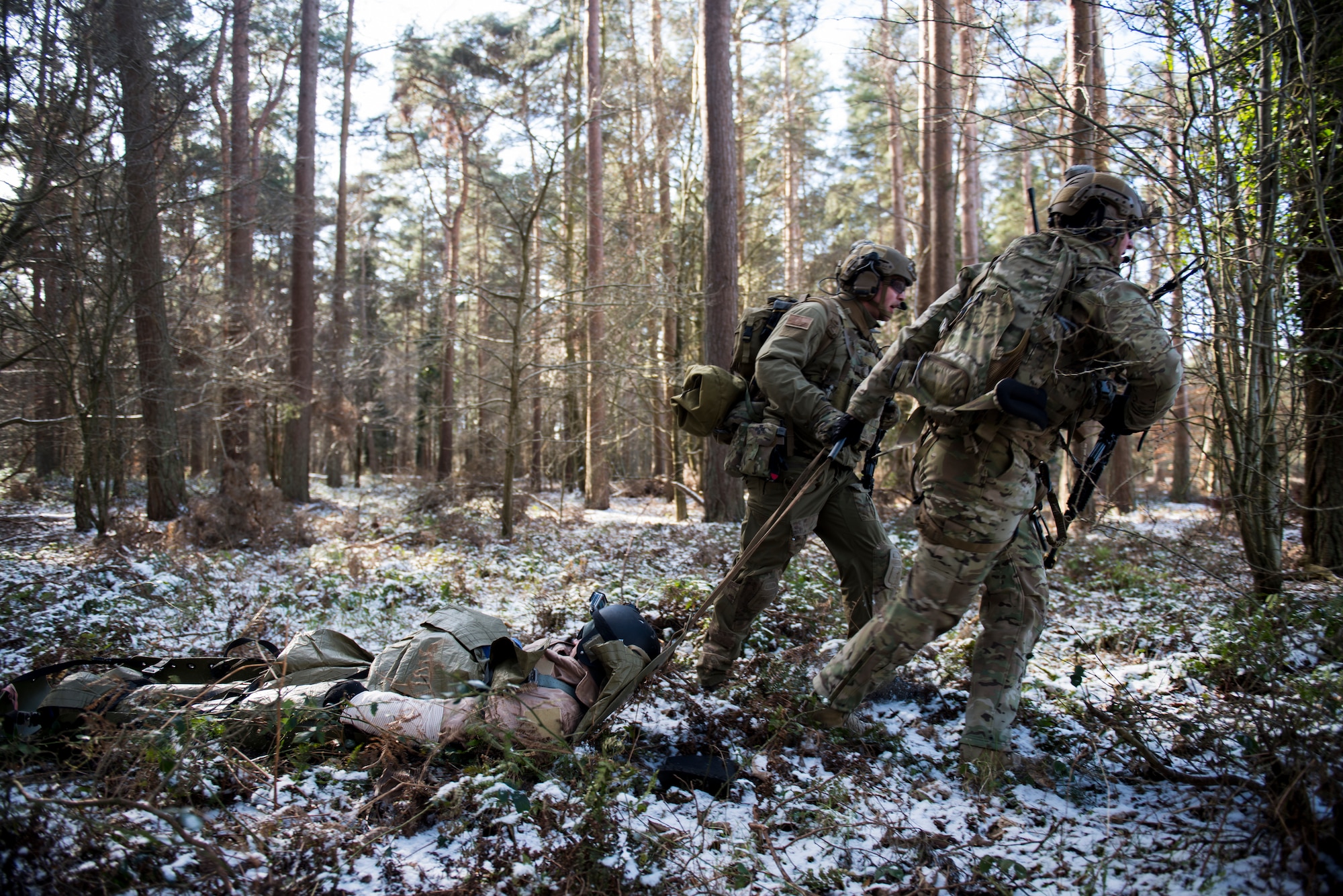 Several 57th Rescue Squadron pararescuemen perform a simulated rescue of a pilot during a training scenario for exercise Point Blank at the Stanford Training Area, England, Feb. 27. Exercise Point Blank is a recurring large force exercise designed and cohosted by the 48th Fighter Wing and the Royal Air Force. (U.S. Air Force photo/Senior Airman Malcolm Mayfield)