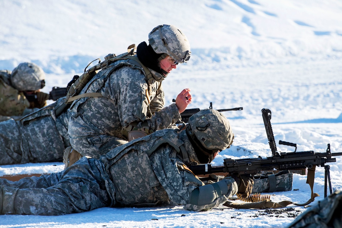 Army Sgt. Melissa Burdge, top center, instructs a soldier during M249 light machine gun live-fire training.