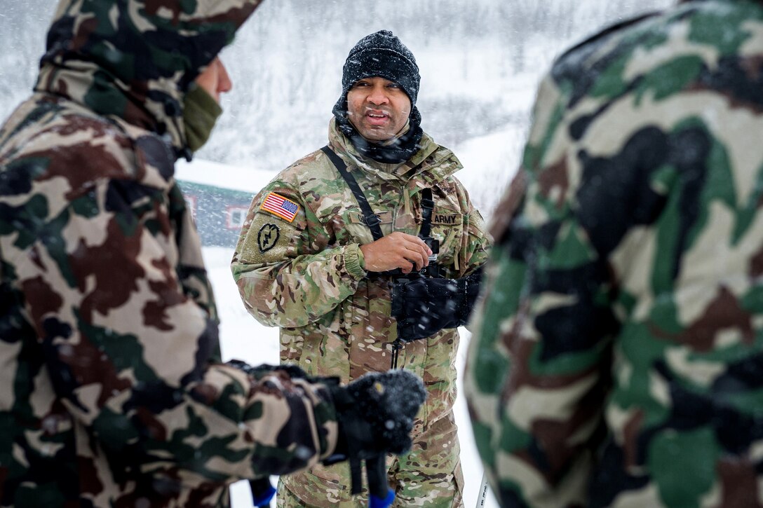 A U.S. soldier, course safety instructor watches as allied, and partner-nation soldiers participate in the Cold Regions Military Collaborative Training Event.