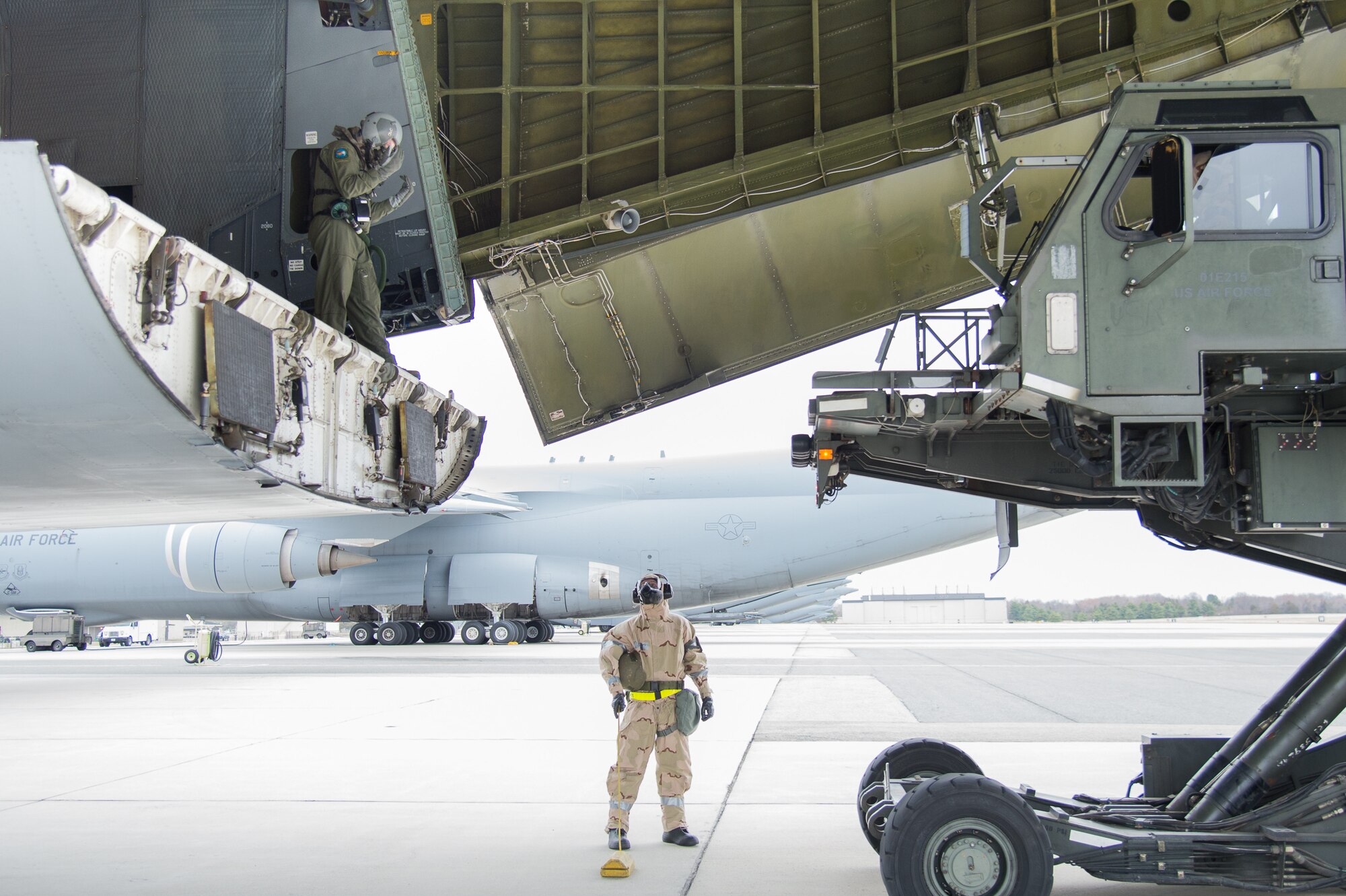 Team Dover Airmen offload a C-5M Super Galaxy wearing full MOPP gear during the 2018 Vengeant Eagle Exercise Feb. 22, 2018, at Dover Air Force Base, Del. One of the many tasks during the exercise was to land and offload cargo in a simulated contaminated environment. (U.S. Air Force photo by Mauricio Campino)