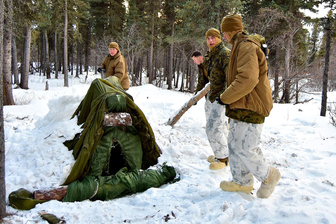 Marines work to construct a thermal shelter.
