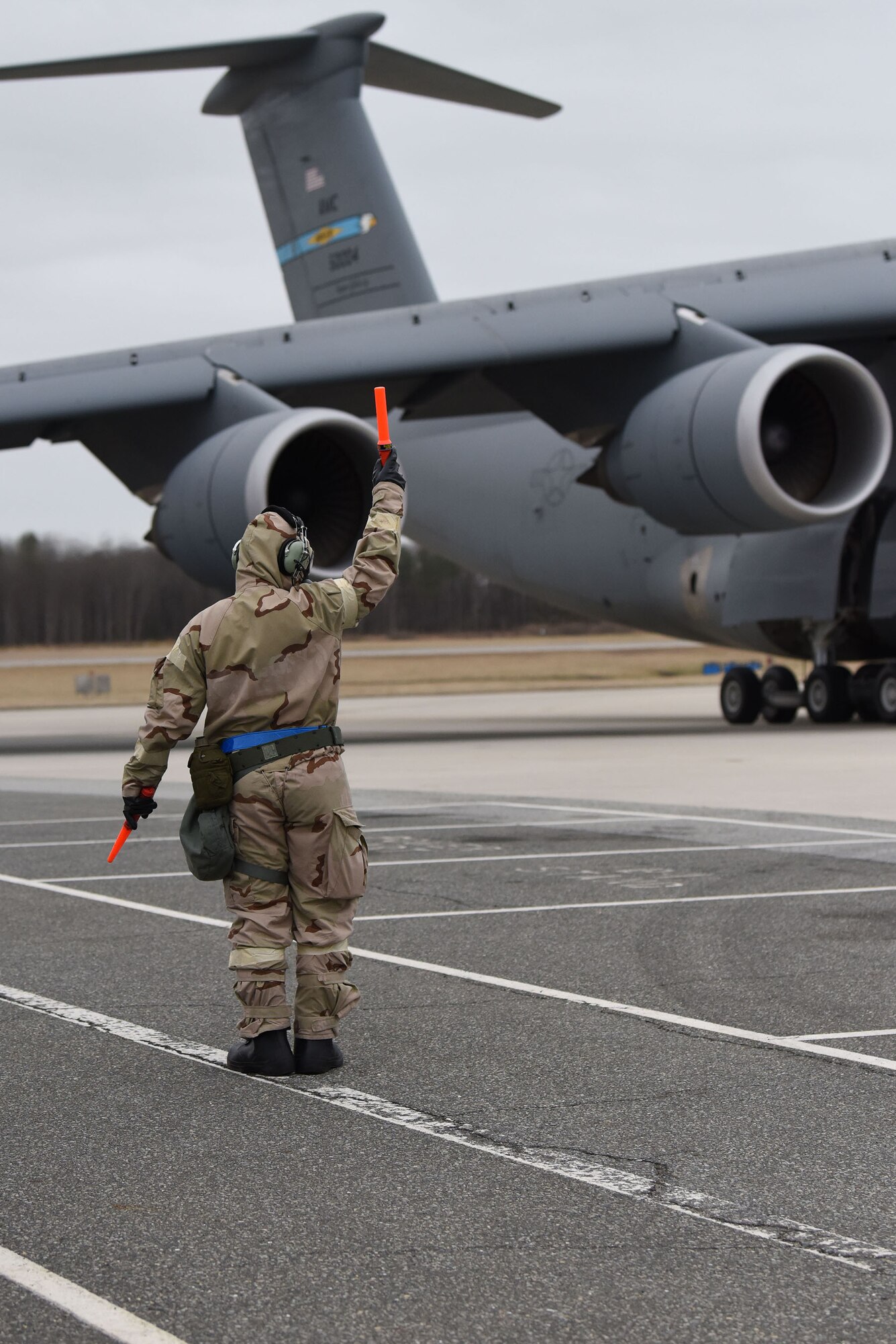 Staff Sgt. Nikko Kuusinen, a 436th Aircraft Maintenance Squadron, C-5M Super Galaxy crew chief, marshals in a C-5M during the 2018 Exercise Vengeant Eagle Feb. 22, 2018. Airmen performed their jobs in Mission Oriented Protective Posture, MOPP, gear the same way they would on a regular day. (U.S. Air Force photo by Airman 1st Class Zoe M. Wockenfuss)