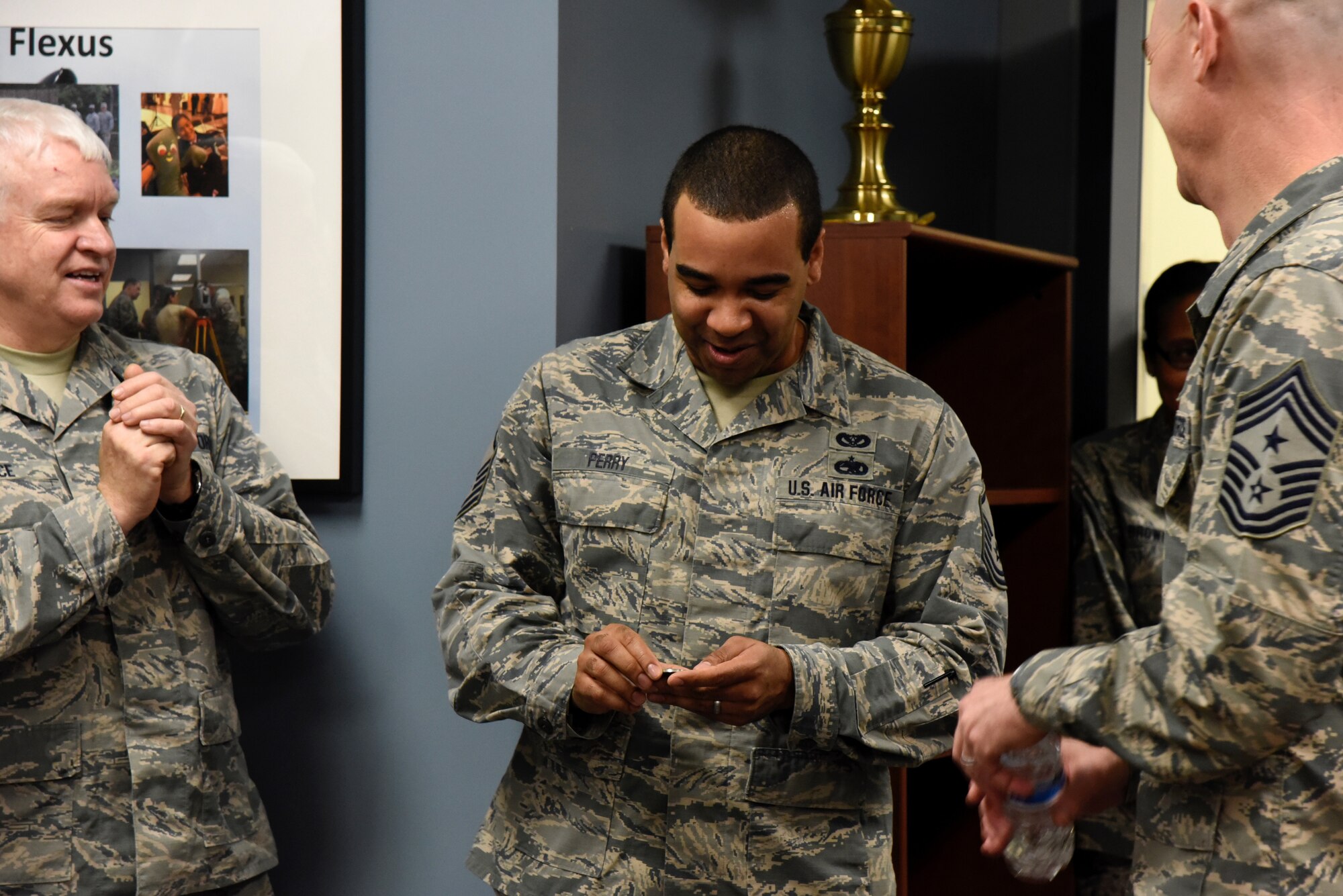 Master Sgt. Dallas Perry,  235th Civil Engineering Flight program analyst, observes the coin he just received from Command Chief Master Sgt. Ronald C. Anderson Jr., Command Chief Master Sergeant of the Air National Guard, and Lt. Gen. L. Scott Rice, the Director of the Air National Guard, February 10, 2018 at Warfield Air National Guard Base, Middle River, Md.