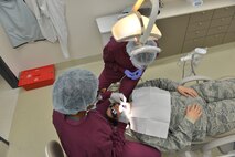 U.S. Air Force Major DeAndra Price-Newby, 633rd Medical Group general dentist (left) performs a dental exam at Joint Base Langley-Eustis, Virginia., Jan. 30, 2018.