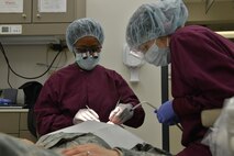 U.S. Air Force Major DeAndra Price-Newby, 633rd Medical Group general dentist (left) performs a dental exam at Joint Base Langley-Eustis, Virginia., Jan. 30, 2018.