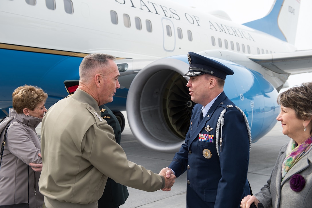 The chairman of the joint chiefs of staff shakes hands with an Air Force officer.