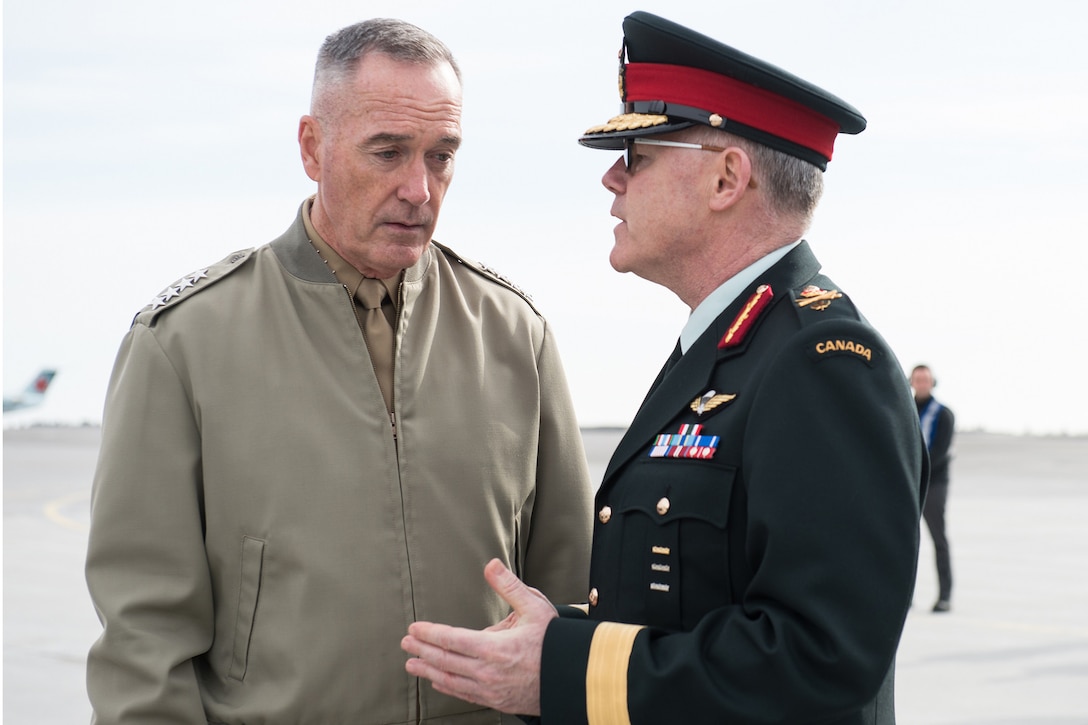 The chairman of the joint chief of staff speaks to a Canadian officer.