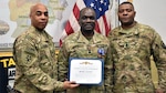 Army Col. James Ellerson, commander for the Area Support Group Afghanistan, and Army Command Sergeant Major Lloyd Moore, present Henry Nettey with the Global War on Terrorism medal and certificate, along with other accolades for his recent deployment. Nettey is currently a contract administrator at Defense Contract Management Agency Hampton in Virginia. (Photo courtesy of Don Baumgartner)
