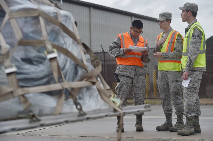 From left to right, Tech. Sgt. Elmer Sanchez, Airman 1st Class Tyler Connolly and Airman 1st Class Michael Carey, all with the 437th Aerial Port Squadron, review a checklist during a simulated cargo inspection at a cargo deployment function as part of mobility exercise Bold Eagle Feb. 26, at Joint Base Charleston, S.C.