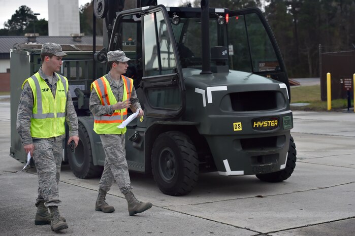 Airman 1st Class Michael Carey, left, 437th Aerial Port Squadron traffic management operations technician, and Airman 1st Class Tyler Connolly, right, 437th APS TMO technician, check equipment during a simulated cargo inspection at a cargo deployment function as part of readiness exercise Bold Eagle Feb. 26, at Joint Base Charleston, S.C.