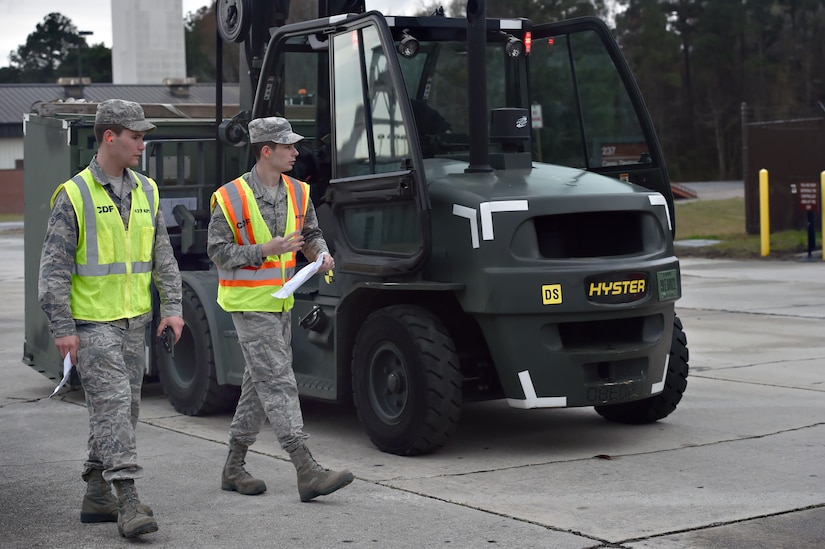 Airman 1st Class Michael Carey, left, 437th Aerial Port Squadron traffic management operations technician, and Airman 1st Class Tyler Connolly, right, 437th APS TMO technician, check equipment during a simulated cargo inspection at a cargo deployment function as part of readiness exercise Bold Eagle Feb. 26, at Joint Base Charleston, S.C.