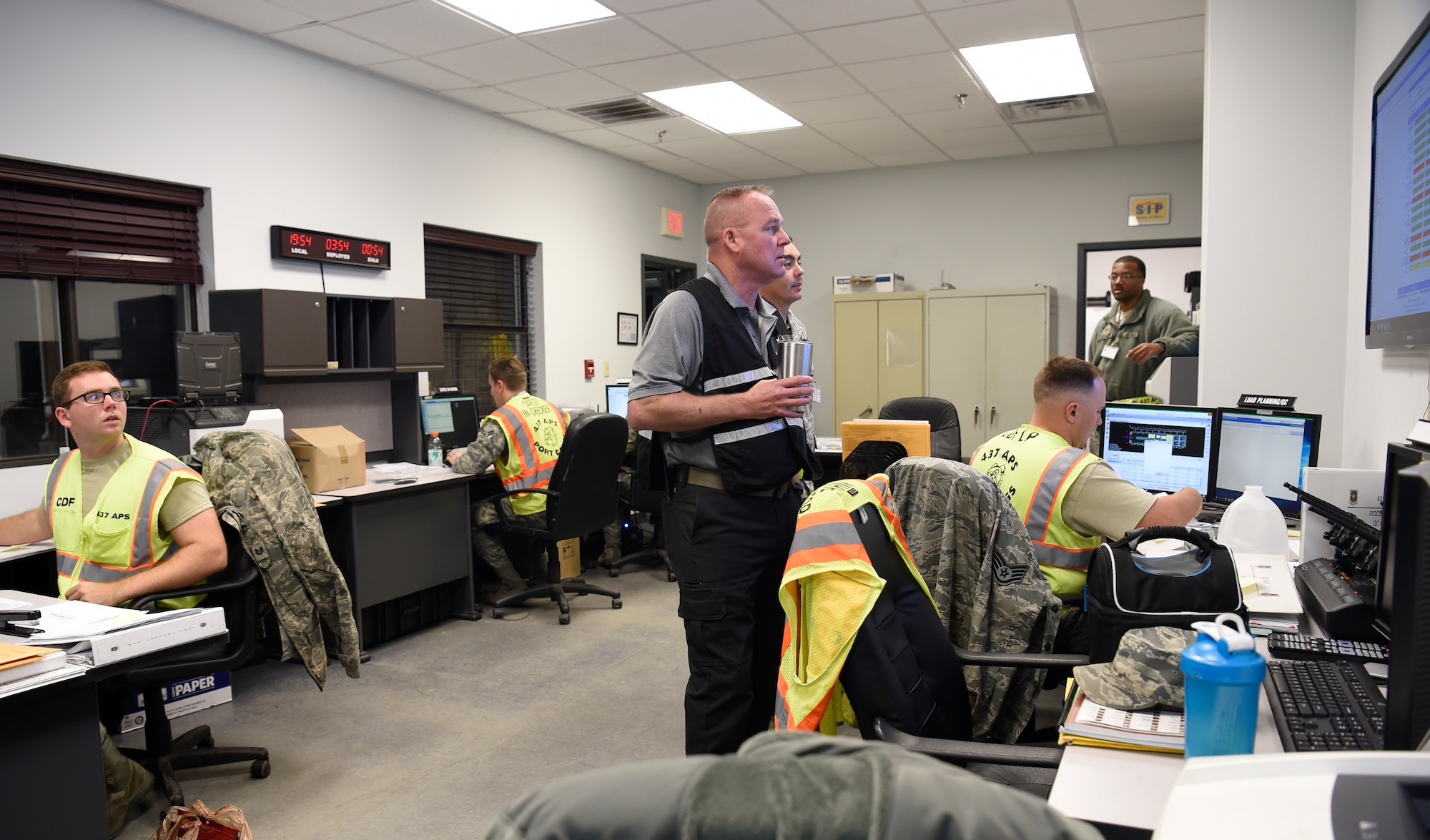 Members of the 437th Aerial Port Squadron air transportation flight, observe the postings for incoming and outgoing cargo at a cargo deployment function as part of readiness exercise Bold Eagle Feb. 26, at Joint Base Charleston, S.C.