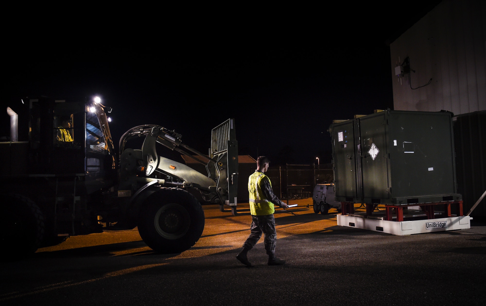 Airman 1st Class Benuel Harmon, 437th Aerial Port Squadron air transportation journeyman, guides Senior Airman Juan Rios, 437th APS forklift operator, through a cargo deployment function as part of mobility exercise Bold Eagle Feb. 26, at Joint Base Charleston, S.C.