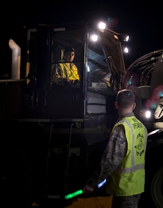 Airman 1st Class Benuel Harmon, 437th Aerial Port Squadron air transportation journeyman, guides Senior Airman Juan Rios, 437th APS forklift operator, through a cargo deployment function as part of mobility exercise Bold Eagle Feb. 26, at Joint Base Charleston, S.C.
