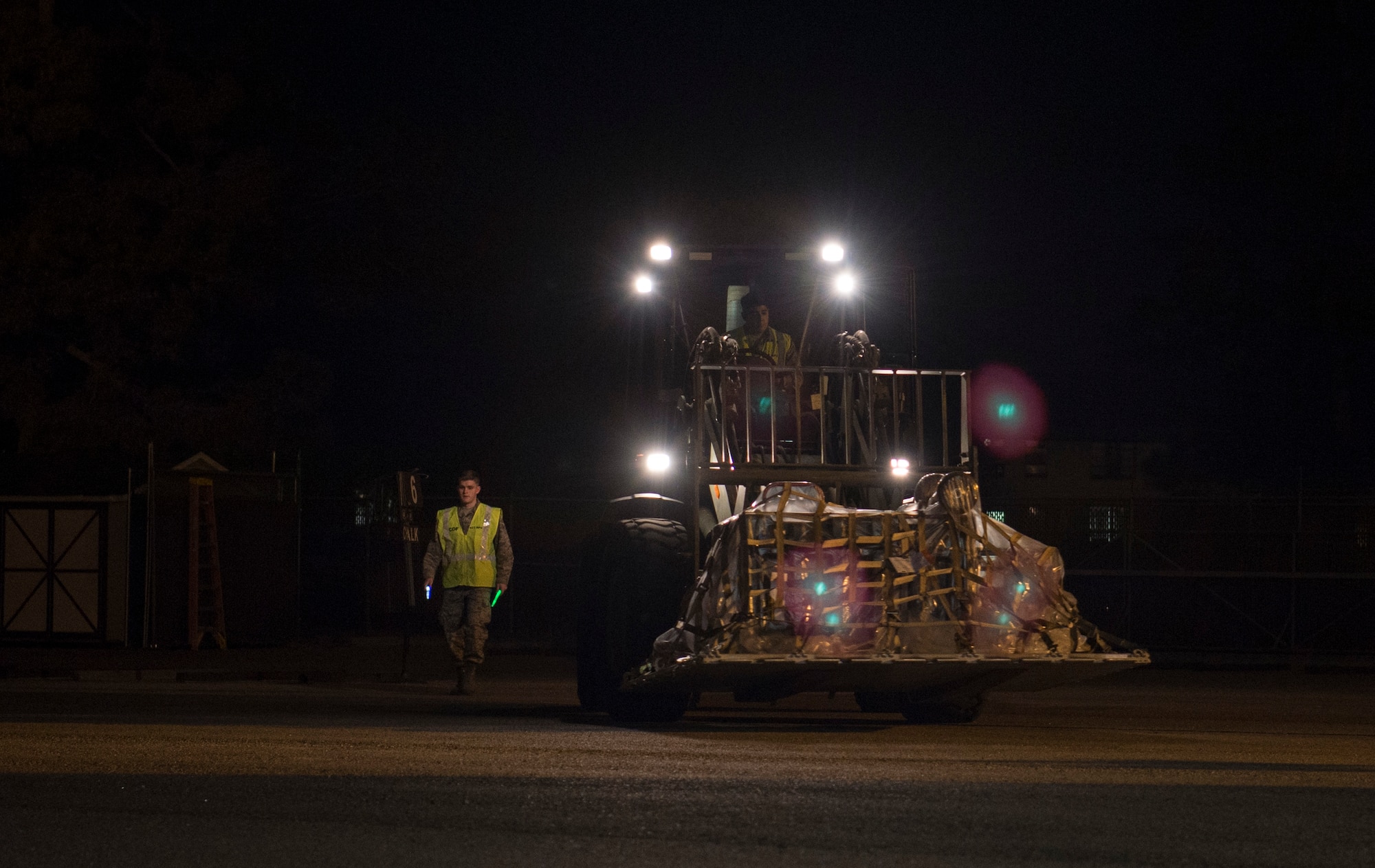 Airman 1st Class Benuel Harmon, 437th Aerial Port Squadron air transportation journeyman, guides Senior Airman Juan Rios, 437th APS forklift operator, through a cargo deployment function as part of mobility exercise Bold Eagle Feb. 26, at Joint Base Charleston, S.C.