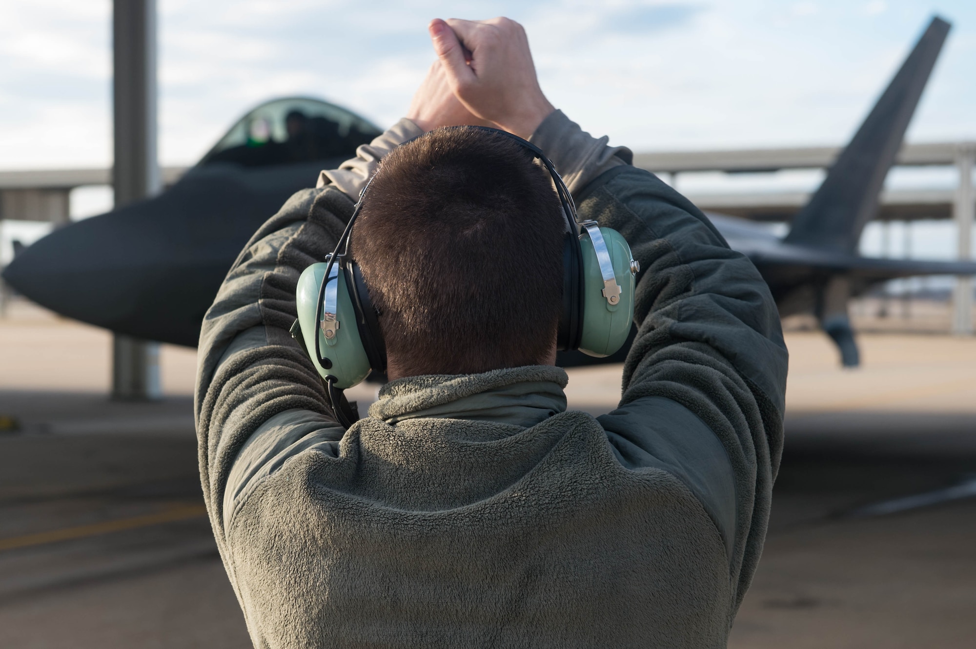 U.S. Air Force Senior Airman Preston Reed, 1st Aircraft Maintenance Squadron, 94th Tactical Aircraft Maintenance Squadron crew chief, guides an F-22A Raptor into its parking spot at Joint Base Langley-Eustis, Virginia, Feb. 14, 2017. Reed performs post-flight inspections of the hydraulic systems, landing gears and electrical systems for any damage that needs replaced. (U.S. Air Force photo by Senior Airman Derek Seifert)