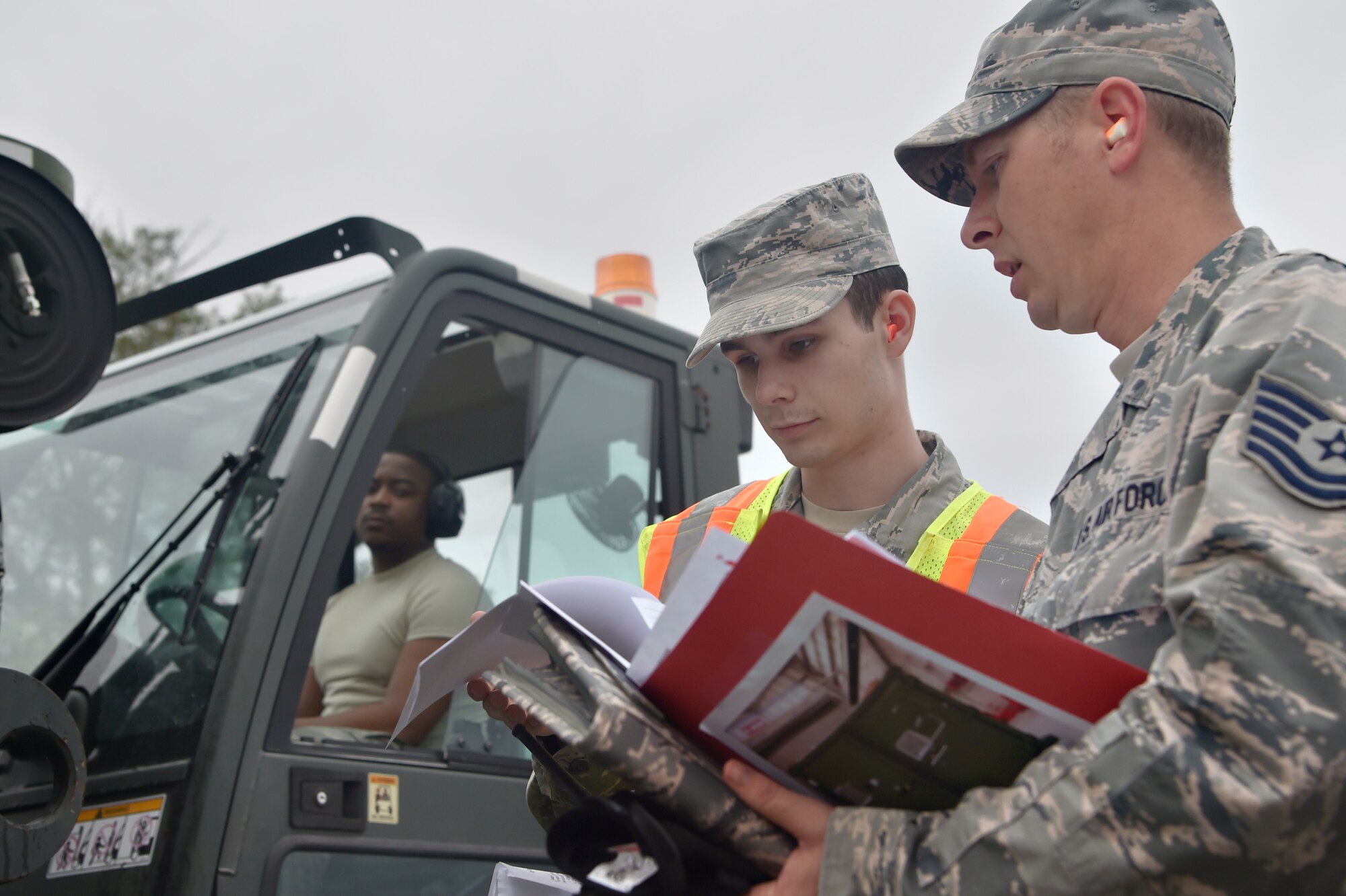 Airman 1st Class Tyler Connolly, center, 437th Aerial Port Squadron traffic management operations technician, and Tech. Sgt. Donovan Reid, right, 437th Aircraft Maintenance Squadron exercise chalk increment monitor, review a checklist during a simulated cargo inspection at a cargo deployment function as part of mobility exercise Bold Eagle Feb. 26, at Joint Base Charleston, S.C.