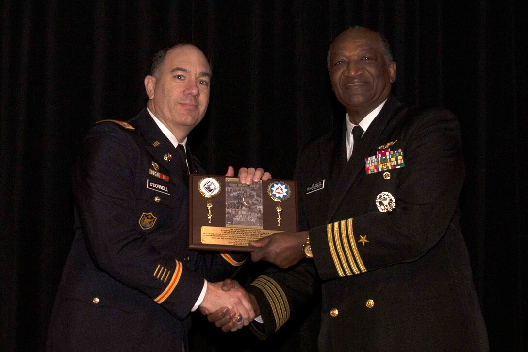 U.S. Army Lt. Col. Jeffrey O'Donnell, 93rd Signal Brigade S5 presents retired U.S. Navy Capt. Edward W. Gantt with an award at a Black History Month ceremony in at Joint Base Langley-Eustis, Virginia, Feb. 23, 2018. Gantt was recognized by O'Donnell as a token of appreciation on behalf of the 93rd Signal Brigade Commander, U.S. Army Col. Kevin D. Litwhiler and the entire JBLE community. (U.S. Air Force photo by Airman 1st Class Monica Roybal)