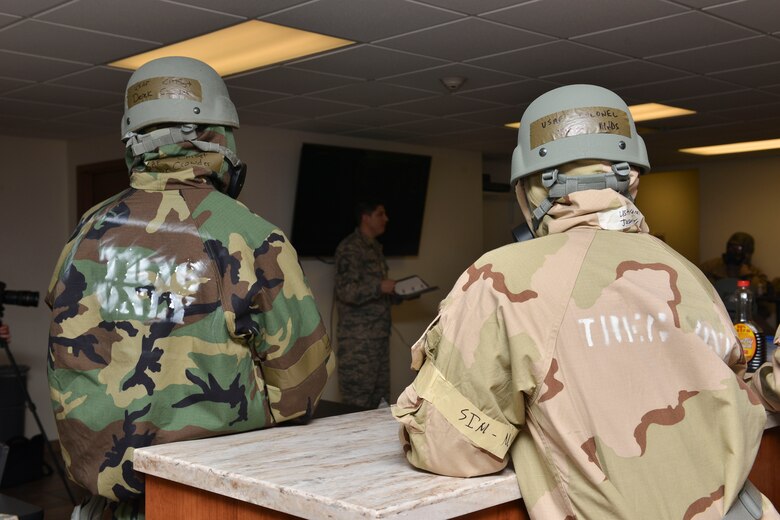 U.S. Air Force Chief Master Sgt. Derek Crowder, 1st Fighter Wing command in chief (left) and Col. Jason Hinds, 1 FW commander (right) listen to exercise feedback at Joint Base Langley-Eustis, Virginia, Feb. 26, 2018.