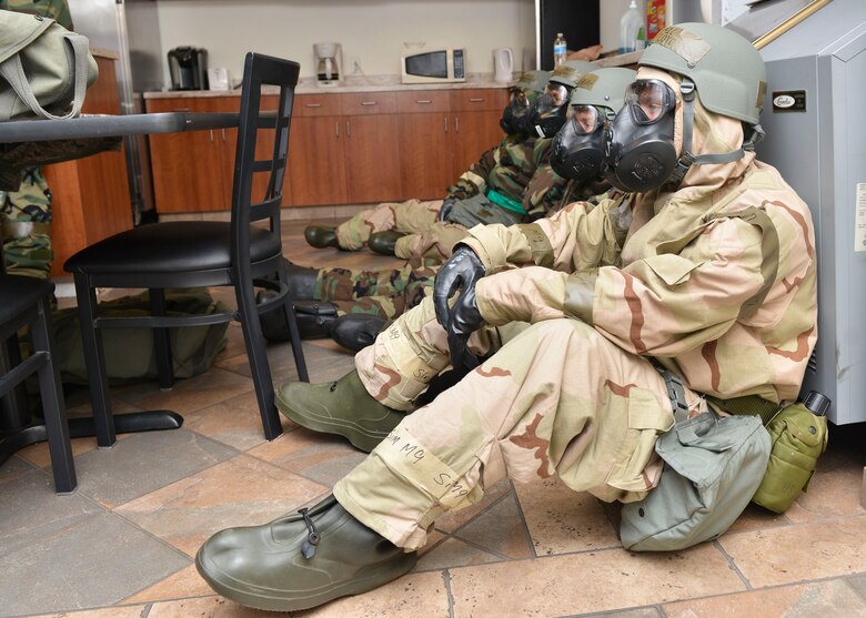 U.S. Air Force Airmen sit down for a brief break during a Chemical Attack Survival Familiarization exercise at Joint Base Langley-Eustis, Virginia, Feb. 26, 2018.