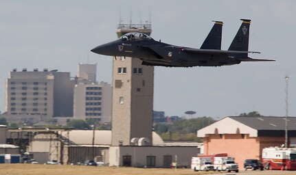 An F-15E Strike Eagle flies past the current air control tower at Joint Base San Antonio-Kelly Field, Texas Oct. 31, 2008.