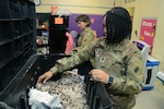 1st Sgt. Charmaine Reyna (right) and Capt. Debe Clark, Headquarters and Headquarters Battalion, U.S. Army South, at Joint Base San Antonio-Fort Sam Houston, sort through winter coats at Booker T. Washington Elementary School Feb. 22.  The company held a coat drive at U.S. Army South from Jan. 8 to Feb. 1, for the young students. The school and battalion are partnered through the Adopt-a-School program.