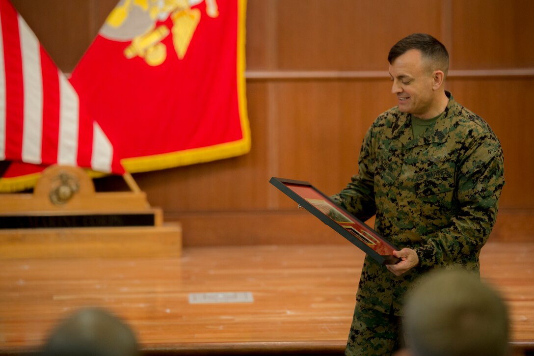 Sgt. Maj. Michael J. Rowan, sergeant major of Headquarters Battalion, Marine Forces Reserve, smiles as he receives a parting gift from the Marines of Headquarters Battalion, MARFORRES, during his relief and appointment ceremony held at Marine Corps Support Facility, New Orleans, Feb. 28, 2018.