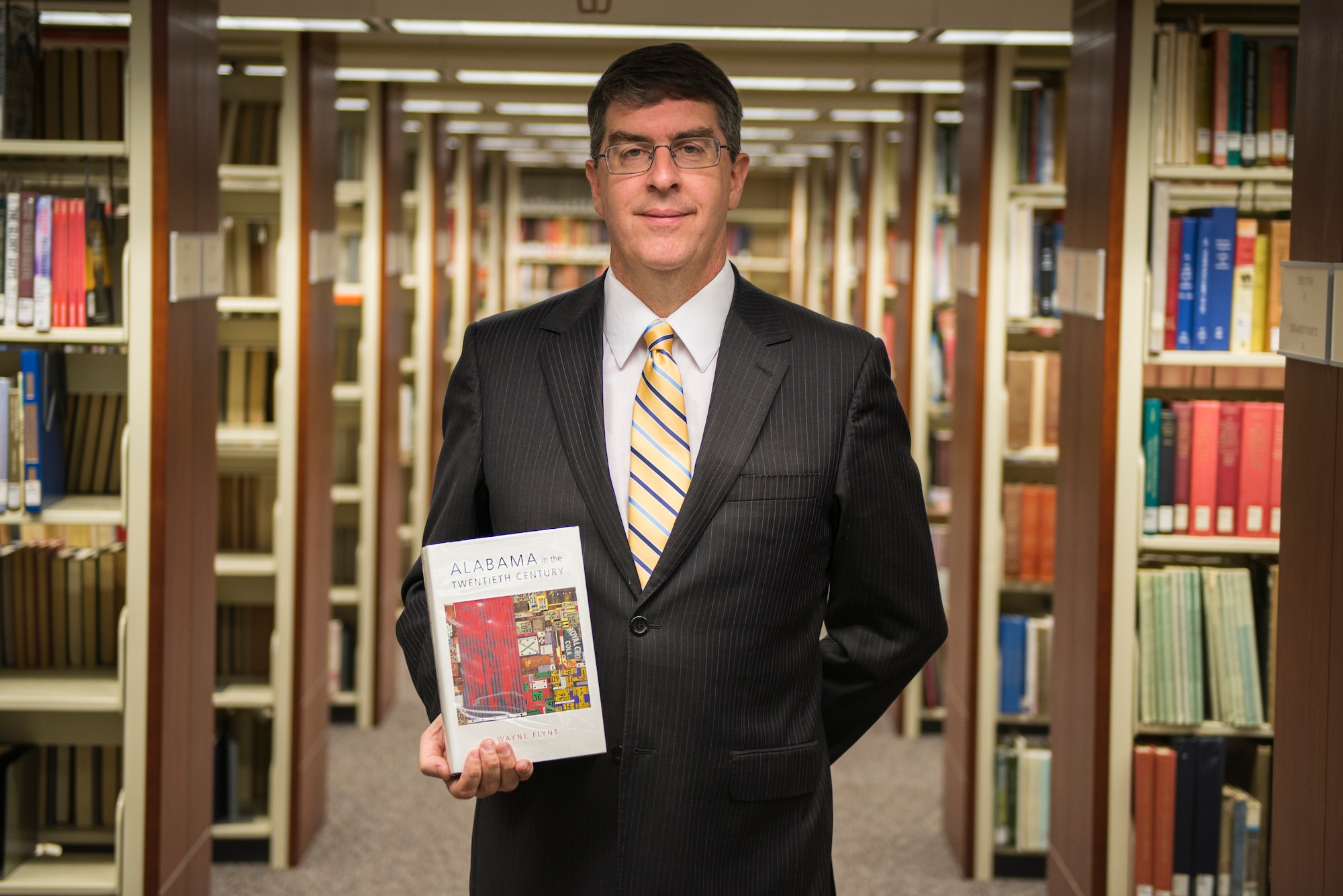 New MSFRIC director stands among the book shelves of the library.