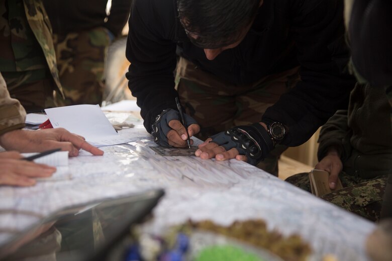 An Afghan Soldier with 1st Brigade plots updated friendly and enemy locations during operation Maiwand 10 in Helmand Province, Afghanistan, Dec. 26, 2017. Task Force Southwest is advising and assisting the 1st Brigade as they clear southern Marjah as part of the Maiwand 10 mission. This is a joint operation with maneuver elements from the Afghan National Army, National Directorate of Security and Afghan National Police forces. (U.S. Marine Corps photo by Sgt. Justin T. Updegraff)