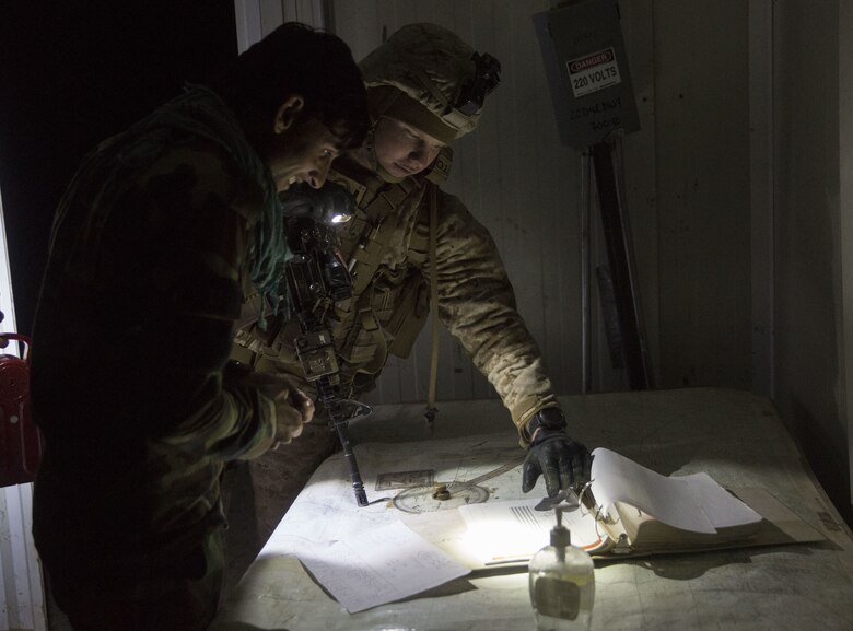 A U.S. Marine advisor with Task Force Southwest assists Afghan National Army Capt. Jefhat, the artillery officer with 1st Brigade, 215th Corps before a fire mission during operation Maiwand 10 in Helmand Province, Afghanistan, Dec. 27, 2017. The artillerymen with 1st Brigade fired an illumination round near a bed-down site to raise the morale of the Afghan National Army Soldiers, showcasing that they can provide artillery support at any time during the operation. (U.S. Marine Corps photo by Sgt. Justin T. Updegraff)