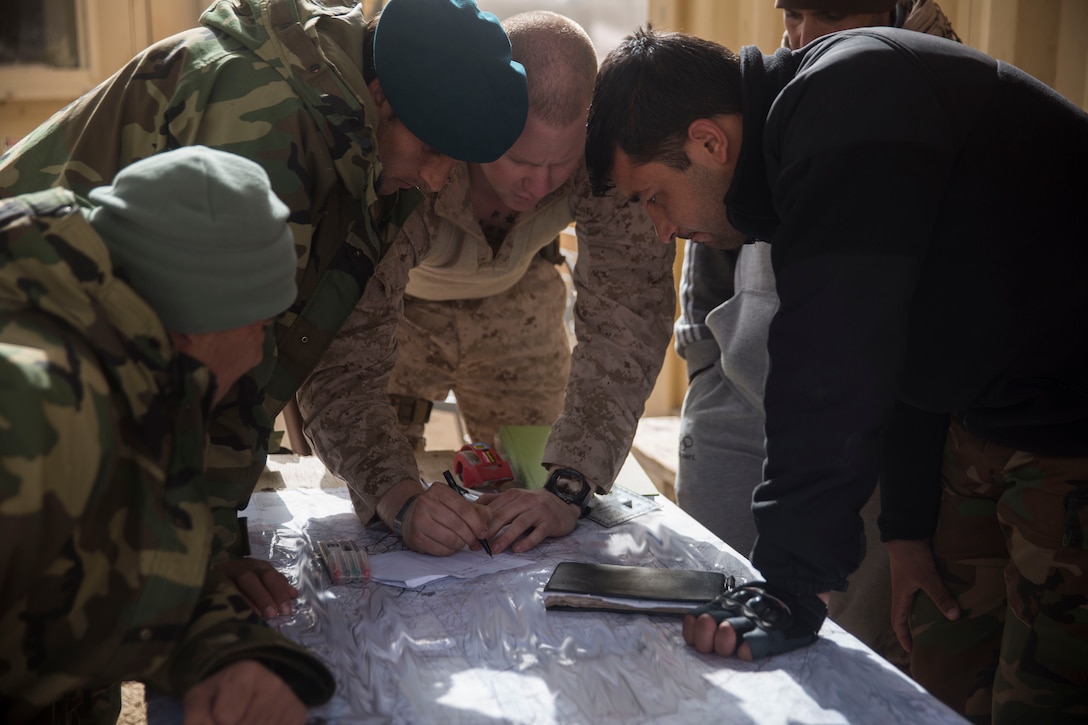 A U.S. Marine advisor with Task Force Southwest teaches various techniques on how to plot and mark friendly and enemy locations on a map during operation Maiwand 10 in Helmand Province, Afghanistan, Dec. 27, 2017. Task Force Southwest is advising and assisting the 1st Brigade as they clear southern Marjah as part of the Maiwand 10 mission. This is a joint operation with maneuver elements from the Afghan National Army, National Directorate of Security and Afghan National Police forces. (U.S. Marine Corps photo by Sgt. Justin T. Updegraff)